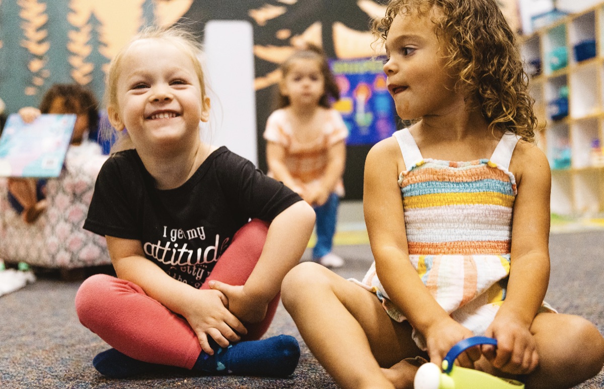 Two young girls smiling during circle time